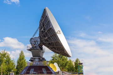 Soviet satellite dish antenna Orbita against blue sky background. Old equipment for...