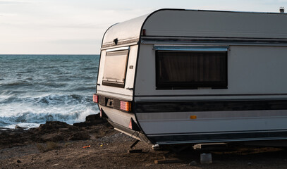 Caravan parked on the seashore. Waves on the water. Scenic camping wild place. Travel. Vacation.