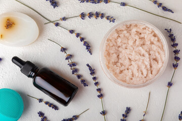 SPA. Lavender flowers, scented candle, body cream, essential oil, scrub and handmade soap. Natural herbal cosmetics with lavender flowers on a white texture background.FLET LAY © Avocado_studio