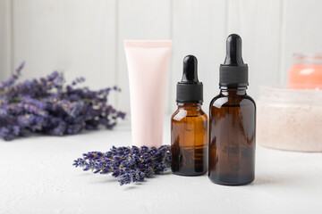 SPA. Lavender flowers, scented candle, body cream, essential oil, scrub and handmade soap. Natural herbal cosmetics with lavender flowers on a white texture background.FLET LAY © Avocado_studio