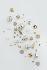Christmas composition with gold and beige Christmas tree decorations: balls, toy trees, stars. Minimalist New Year, winter holidays card