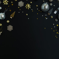 Luxury Christmas, New Year holidays composition with blank copy space. Gold baubles balls, stars on black background. Christmas tree decorations. Flat lay, top view festive template