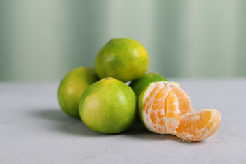 Fresh green-orange tangerines on a gray background. Fruits with a high content of vitamin C.