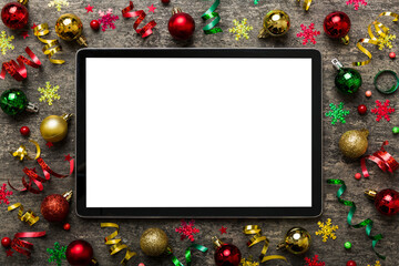 Christmas online shopping from home tablet pc with blank white display top view. Tablet with copy space on colored background with Christmas decorations balls,. Winter holidays sales background