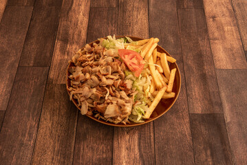 Kebab menu plate with large pile of chicken and lamb meat with salad and chips