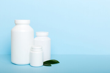 supplement pills with medicine bottle health care and medical top view. Vitamin tablets. Top view mockup bottle for pills and vitamins with green leaves, natural organic bio supplement, copy space