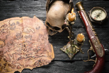 Ancient pirate treasure map and musket gun on the pirate table top view concept background.