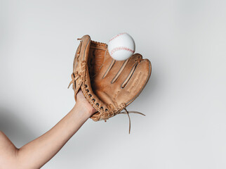 Baseball is caught in a worn baseball glove.