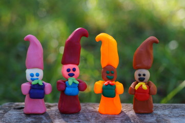 Figures of dwarfs with gifts on a colored background. Funny toys.