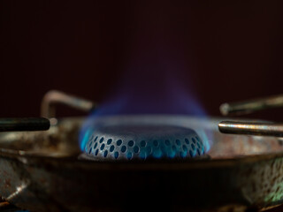 The flame of a gas tourist burner. Blue fire isolated on black background.