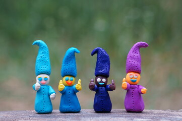 Figures of four colorful dwarfs with thumbs up. Positive mood. Well-being and love. Fairy-tale...