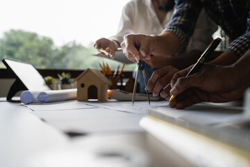 Architect man working with blueprints for architectural plan, engineer sketching a construction project concept