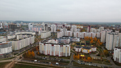 Fototapeta premium Multi-storey buildings with infrastructure. Densely populated urban area. Overcast weather. Autumn landscape. Aerial photography.