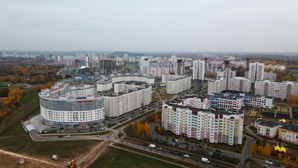 Obraz premium Multi-storey buildings with infrastructure. Densely populated urban area. Overcast weather. Autumn landscape. Aerial photography.