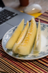 melon sliced next to the laptop