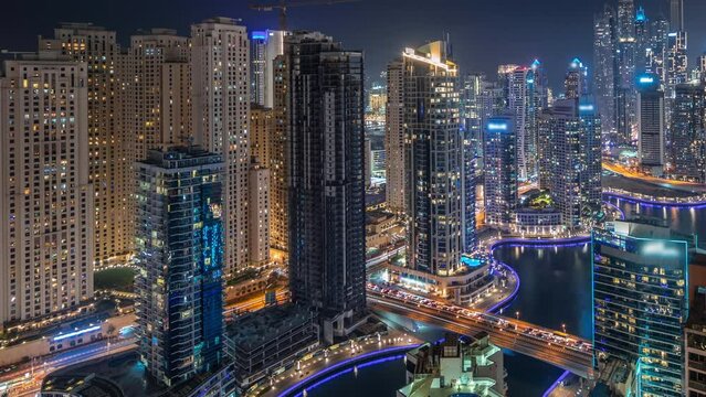 Panorama showing various skyscrapers in tallest recidential block in Dubai Marina and JDR district aerial night timelapse with artificial canal. Many towers and yachts