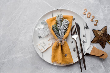 Table setting. A marble plate with a snowflake on a napkin, Christmas tree branches and Christmas...