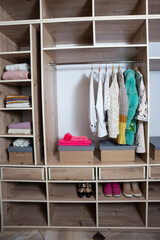 Big wardrobe with different clothes and accessories in dressing room