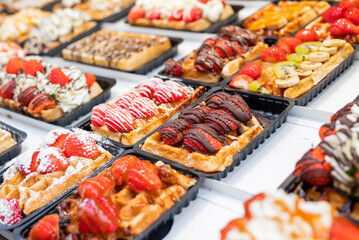 national food waffles in Belgium on the square in pastry shops with chocolate cream and berries
