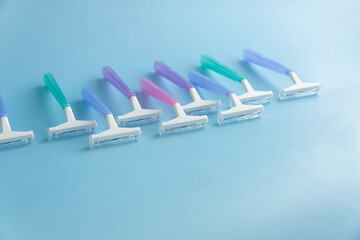 Set of multi-colored disposable razors on a blue background.