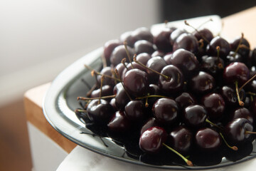 Ripe large cherry in a plate close-up.