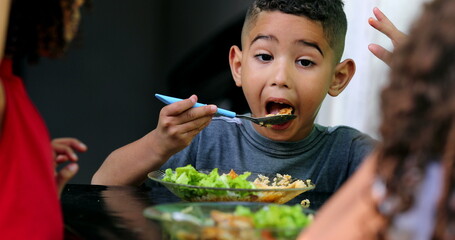 Little mixed race child eating food. Hispanic kids lunch time