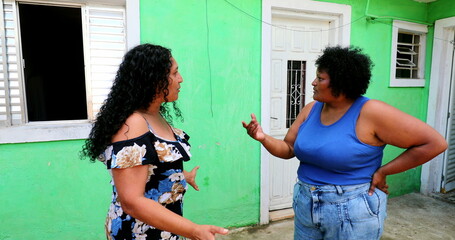 Hispanic women gossiping in emotional conversation. Latinas talk