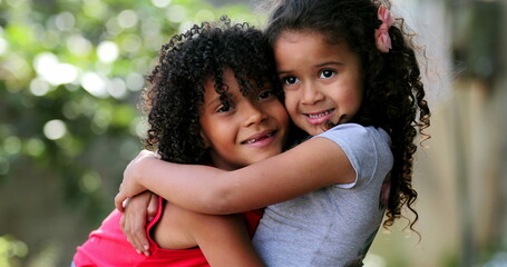Hispanic siblings embrace and hug. Two sisters love