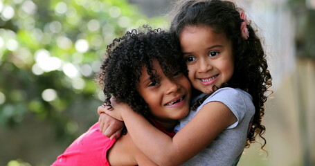 Hispanic siblings embrace and hug. Two sisters love