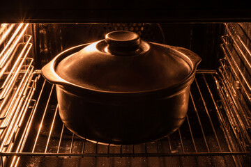 Dark cast iron pot with lid on in the electric oven