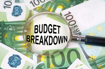 Among the euro banknotes is a magnifying glass with the inscription - BUDGET BREAKDOWN
