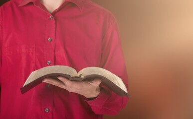 Christian person's hands with open holy Bible book