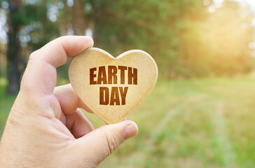 In the hands of a man is a tablet in the form of a heart on which it is written - earth day