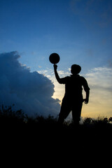 Silhouette of boy with football during sky sunset background, Silhouette of boy playing football 