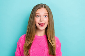 Photo of positive cheerful impressed girl straight hairstyle wear pink knit sweater tongue lick teeth isolated on blue color background