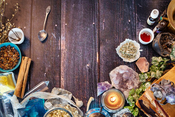 Alchemical lab with crystals, snake skin, potions, herbs, spices, oils, bones, skulls and old books. Witcher workspace with magical equipment. Witch's Magical kitchen concept. Top view, copy space.