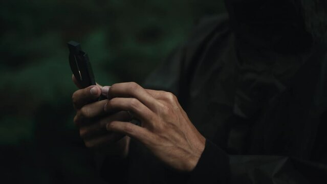 Explorer looks at the compass after he gets lost in the mountains