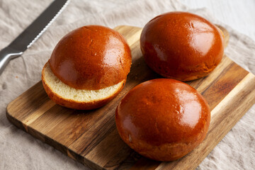Homemade Brioche Hamburger Buns on a wooden board, low angle view. Close-up.
