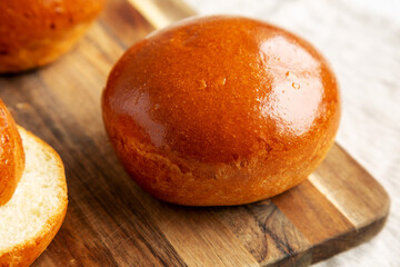 Homemade Brioche Hamburger Buns on a wooden board, side view. Close-up.