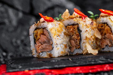 rolls with salmon and shavings on a black background