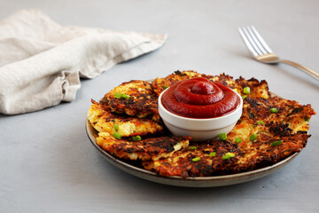 Homemade Cauliflower Cheddar Fritters with Chives on a Plate, side view. Close-up.