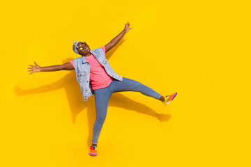 Fototapeta na wymiar Full length photo of overjoyed carefree lady raise opened hands dancing isolated on yellow color background