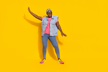 Fototapeta premium Full size portrait of cheerful excited lady enjoy discotheque dancing isolated on yellow color background