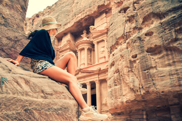 Caucasian tourist traveler sit on viewpoint in Petra ancient city looking at the Treasury or...