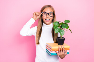 Photo of cheerful clever person toothy smile arm touch eyewear hold book plant isolated on pink color background