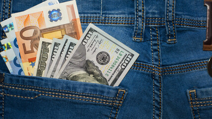 dollar and euro, bills in the pocket of jeans. The concept of pocket money. Cash. American and European money. business, trade or financial transactions, seasonal discounts. wealth. close-up