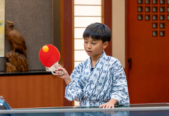 温泉旅行で卓球をするアジア人の男の子
