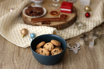 Various Christmas decorations, cup of tea or coffee, sweets, small presents, knitted blanket and candles. Selective focus.