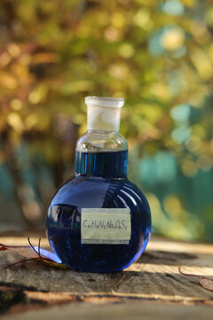 A round flask with a blue aqueous solution of the organic indigo carmine dye.