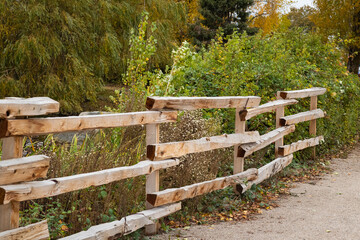 Country Timber Fence. Old wood fence with a green country field behind it. Wooden farm slit rail...